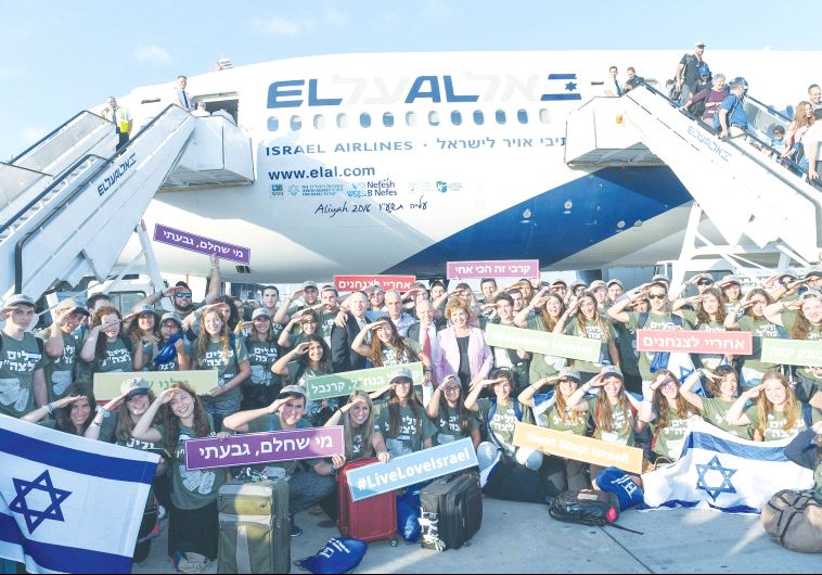 New immigrants pose for a photo with Immigration and Absorption Minister Sofa Landver (center, in pi