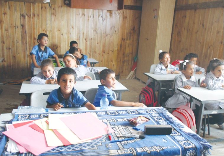 CHILDREN SIT at a Beduin school in al Khan al Amar in the West Bank yesterday. The school is slated 