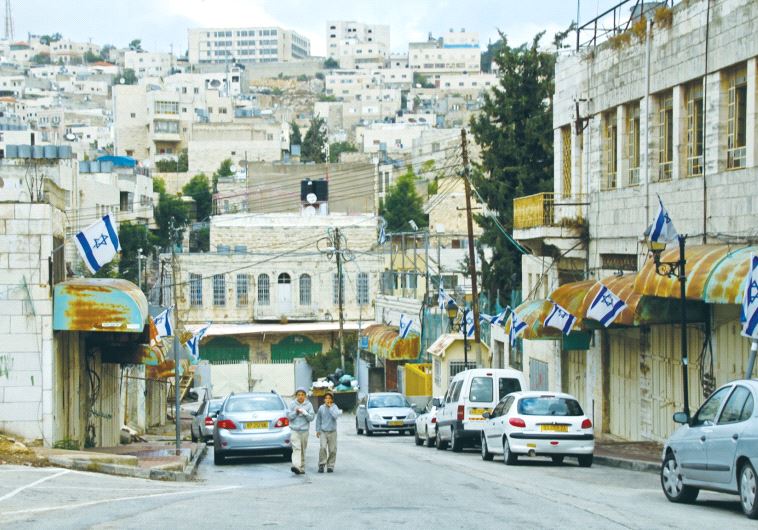 BOYS WALK up a street last winter near Hebron’s yeshiva, close to where the proposed Jewish building