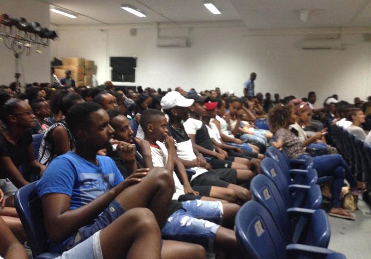 Youth center participants wait in a Lod assembly hall
