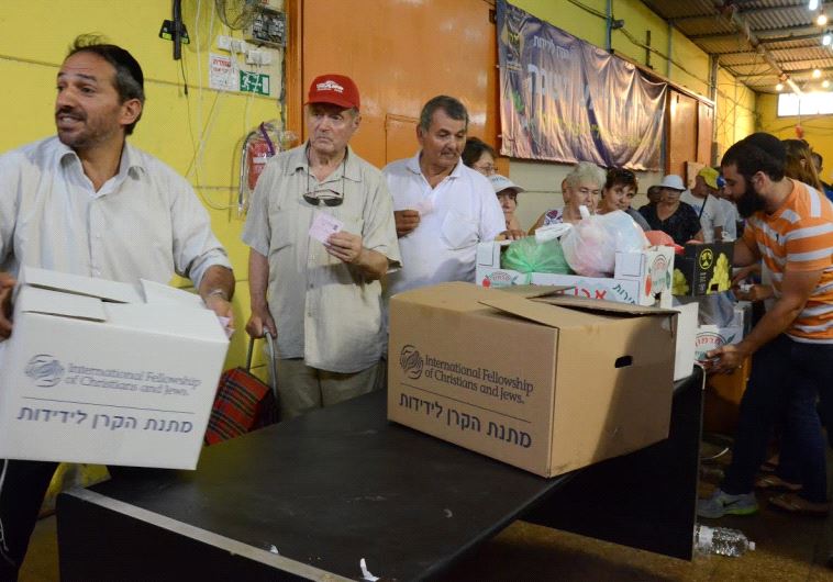 People receive IFCJ food packages prior to Rosh Hashana at the Yad B'Yad warehouse in Lod.