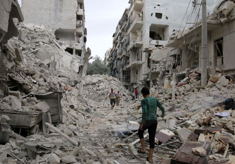 People inspect a damaged site after airstrikes on the rebel held Tariq al-Bab neighbourhood of Alepp