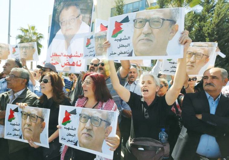 RELATIVES AND ACTIVISTS hold pictures of assassinated Jordanian Christian writer Nahed Hattar yester