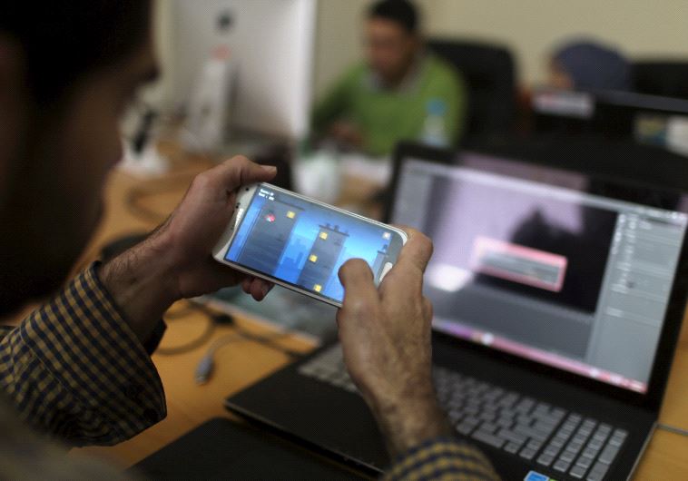 A young Palestinian entrepreneur displays on his mobile a game that he developed at Gaza Sky Geeks o
