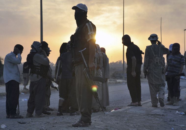 ISIS fighters stand guard at a checkpoint in the northern Iraq city of Mosul.