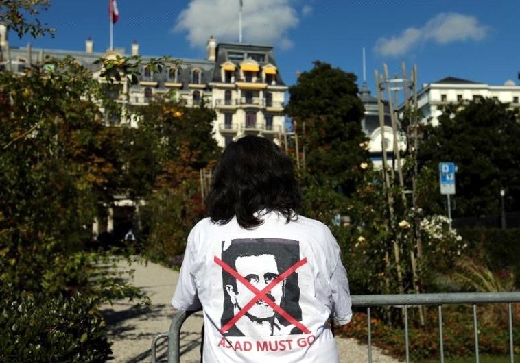A woman stands outside the Beau-Rivage Palace ahead of Syria talks in Lausanne, Switzerland, October