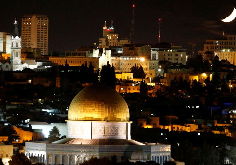 The moon is seen from the Dome of the Rock on the Temple Mount compound.