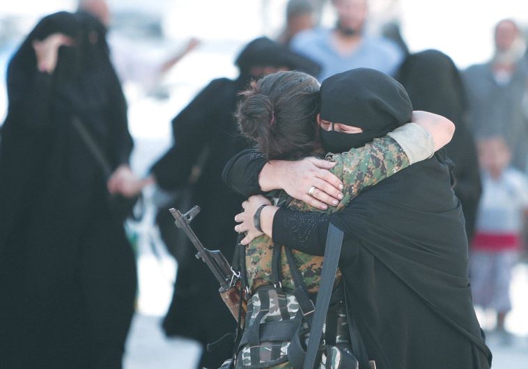 A WOMAN embraces a Syrian Democratic Forces fighter after being liberated from Islamic State control