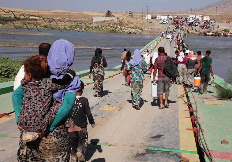 YAZIDI WOMEN and men flee Islamic State on August 10, 2014 in northern Iraq. Many were captured by I