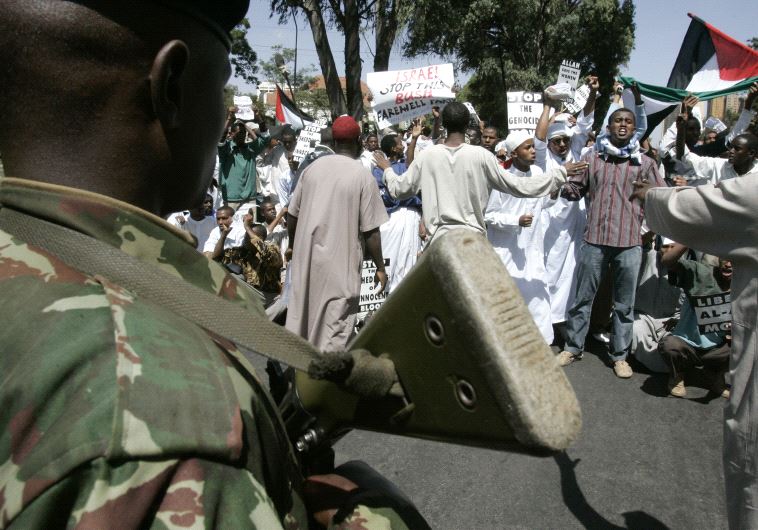 An anti-riot policeman blocks Muslim protesters from marching to the Israeli embassy during a demons