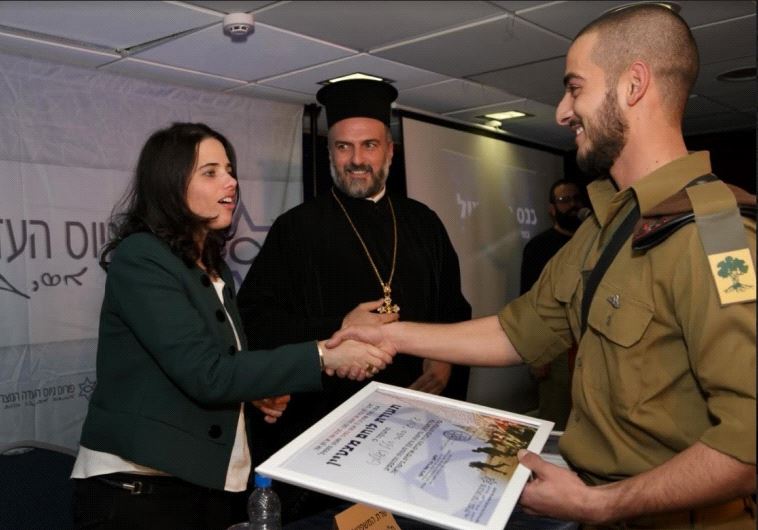 Caption: Justice Minister Ayelet Shaked and Father Gabriel Naddaf hand out an award to a Christian s