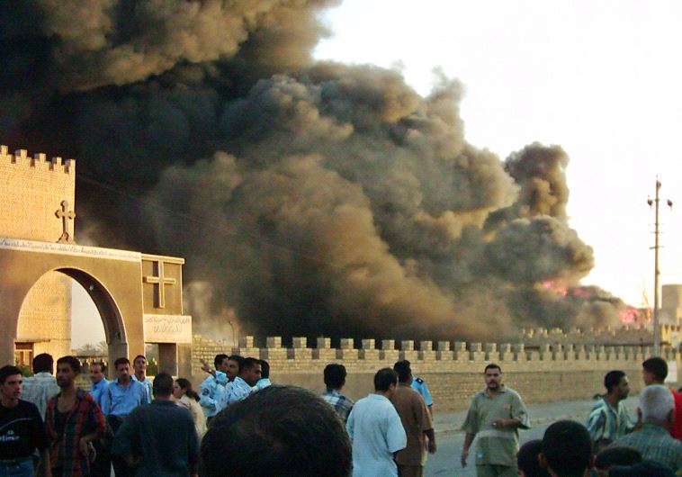 Iraqis crowd the area after an explosion in the car park outside an ancient Chaldean monastery in th