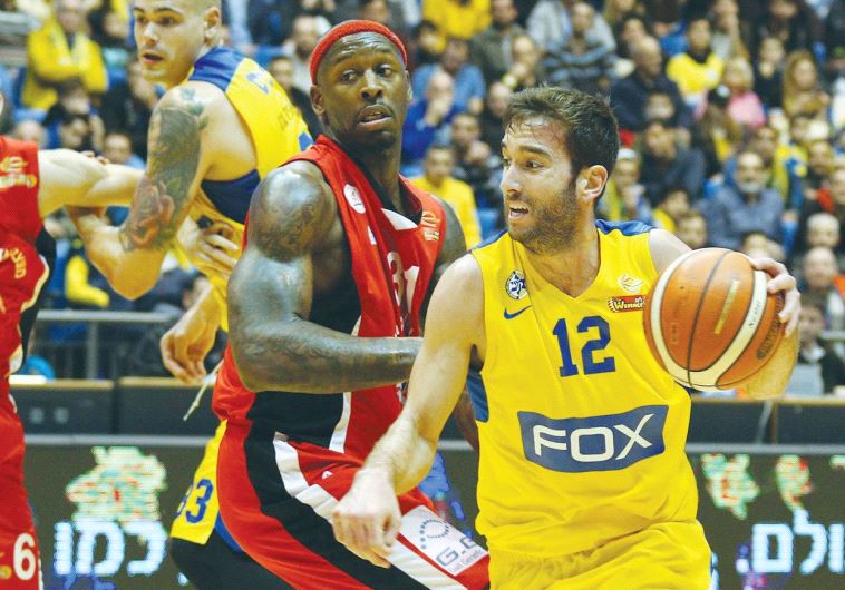 Maccabi Tel Aviv guard Yogev Ohayon (right) drives past Hapoel Gilboa/Galil’s Murphy Holloway during