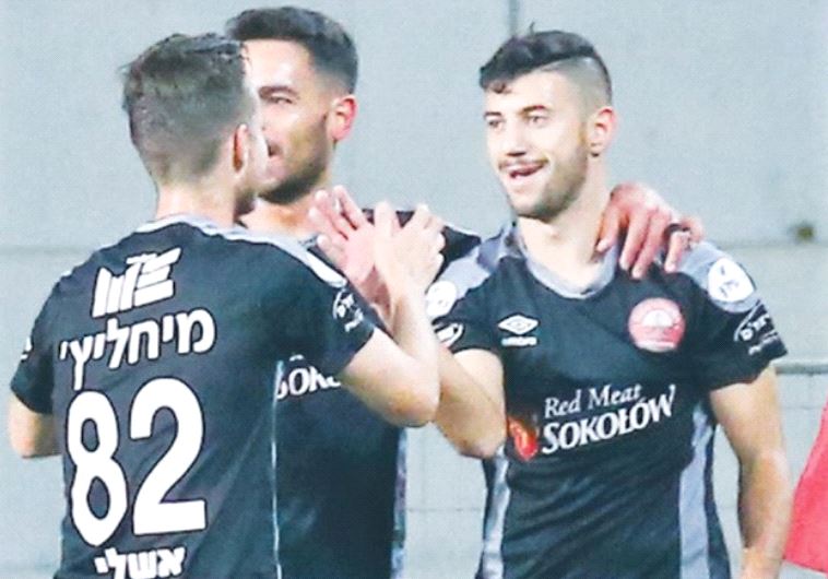 Hapoel Ra’anana midfielder Mohammed Shaker (right) celebrates with teammates after scoring the only 