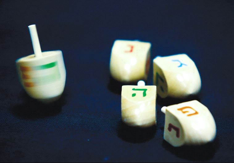 HANUKKA DREIDELS display the letters of the Hebrew acronym for ‘A great miracle happened here.’