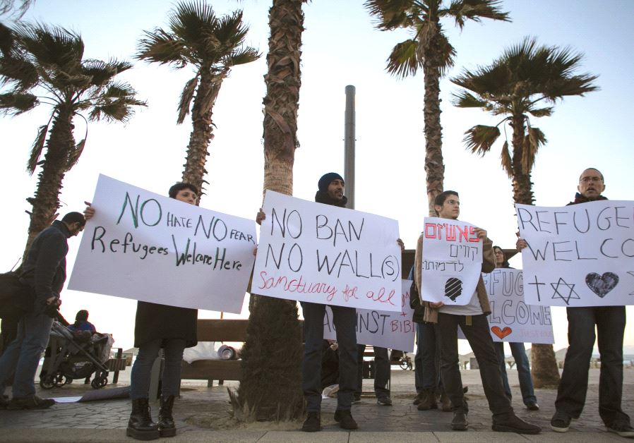 PROTESTERS hold placards during a rally supporting refugees worldwide and in reaction to US Presiden