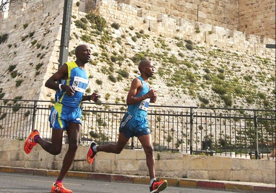 RUNNERS PASS by the walls of the capital’s Old City during Friday’s seventh annual running of the Je