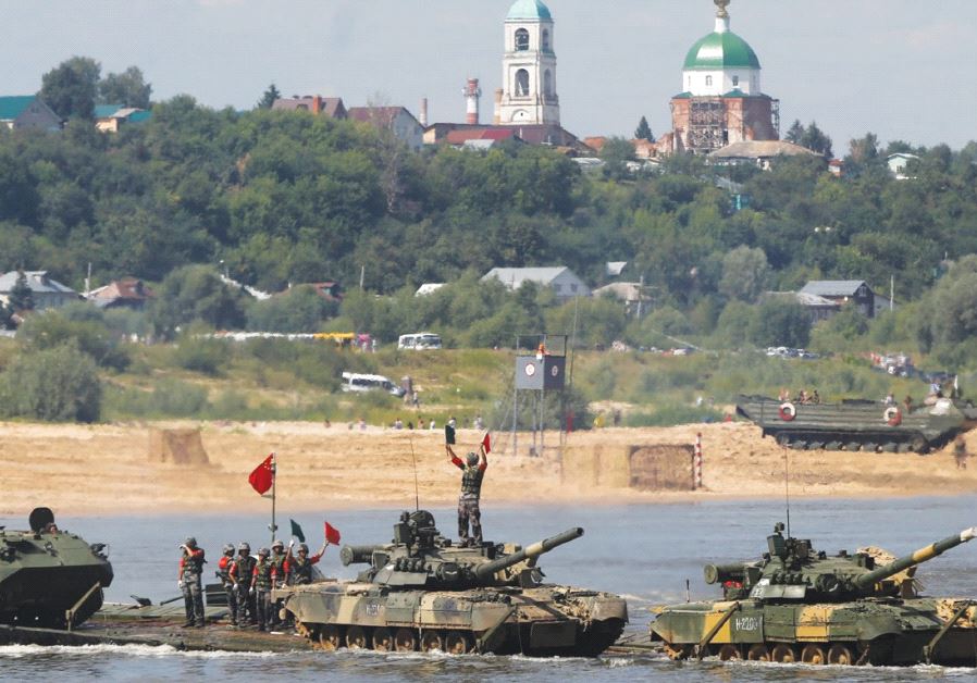 CHINESE CREW members transport T-80 tanks on a pontoon bridge during the Open Water competition for 