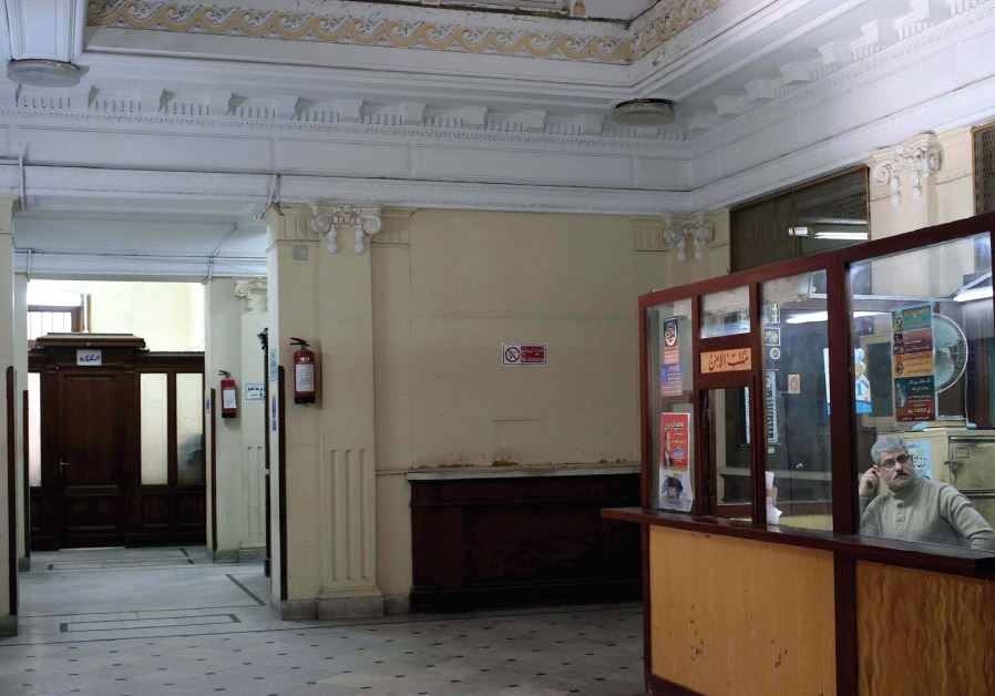 A MAN sits in a security booth at the Nile Company for Medicine on Fouad Street in Alexandria last y