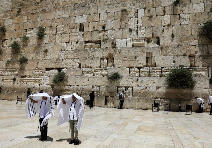 Youth hold their prayer shawls as they stand in front of the Western Wall, May 17, 2017.