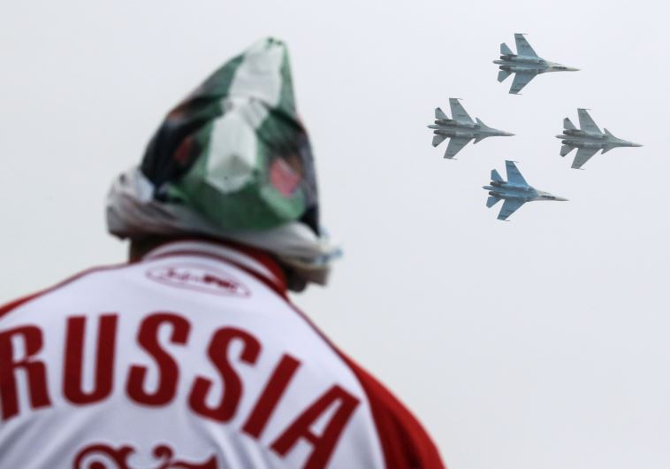 A spectator watches Sukhoi Su-30SM jet fighters of the Falcons of Russia acrobatic team
