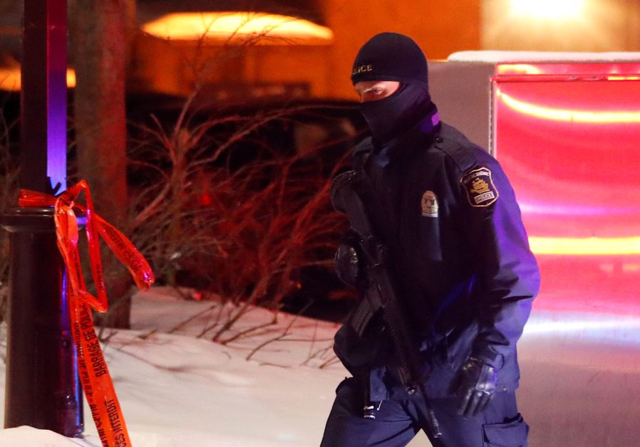 A police officer patrols the perimeter near a mosque after a shooting in Quebec City