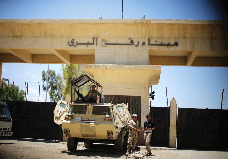 Egyptian soldiers stand guard in front of the Rafah border crossing between Egypt and the southern G