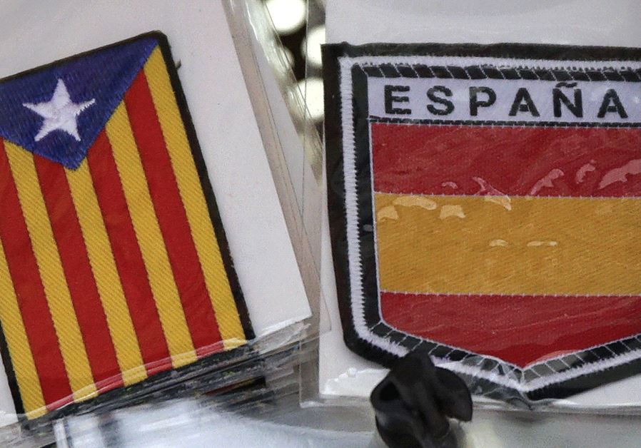 THE COLORS of the Spanish flag are seen next to a Catalan flag in Barcelona.