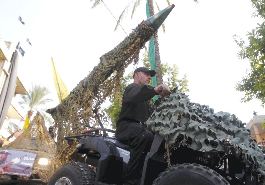 A Hezbollah member drives a 4-wheel motorbike mounted with a mock rocket in southern Lebanon in 2015