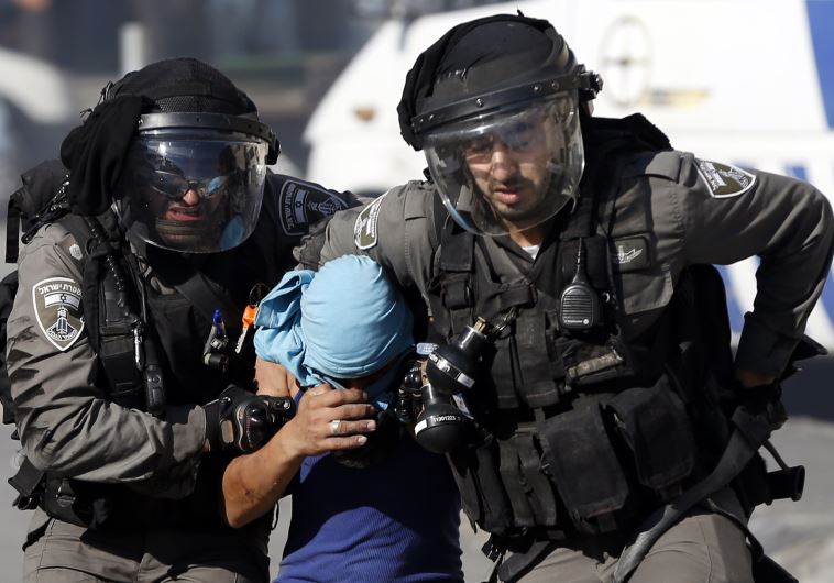 Border Police arrest a Palestinian youth during clashes in the Palestinian refugee camp of Shuafat