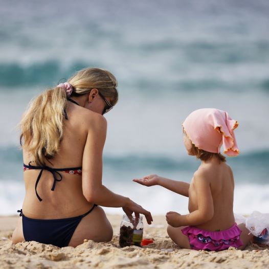 A woman and a girl sit in front of the Mediterranean at the beach in Ashkelon