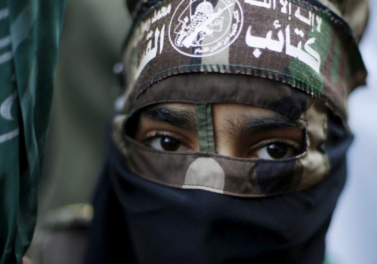 A masked Palestinian boy wearing the headband of Hamas's armed wing