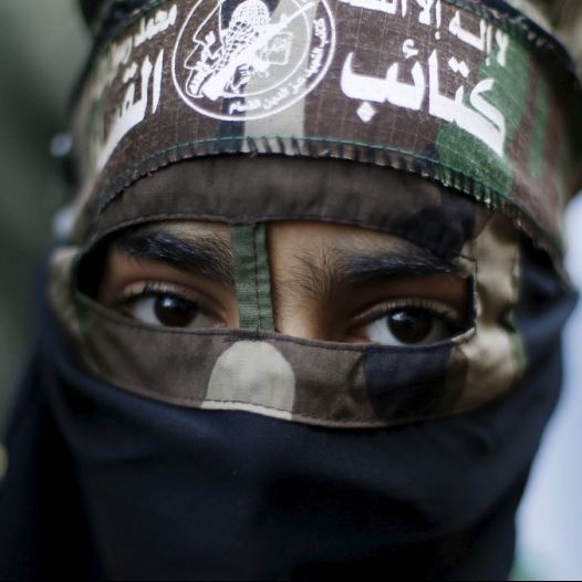 A masked Palestinian boy wearing the headband of Hamas's armed wing