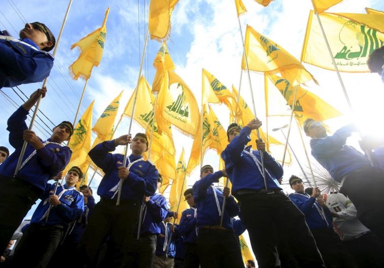 Lebanon's Hezbollah scouts carry their parties flag while marching at the funeral of 3 Hezbollah men