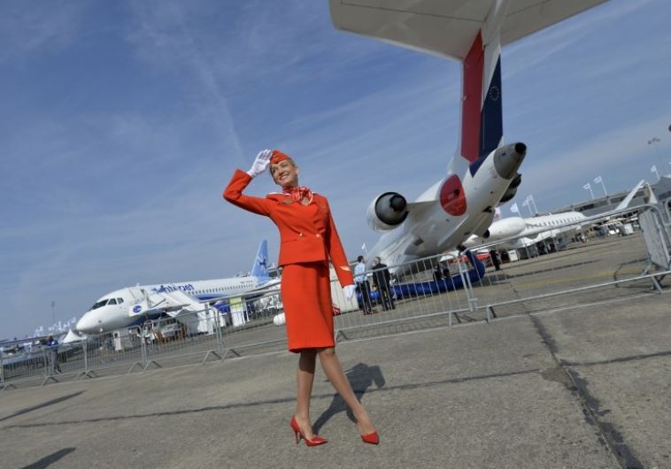 A flight attendant salutes to visitors during the International Paris Airshow at Le Bourget