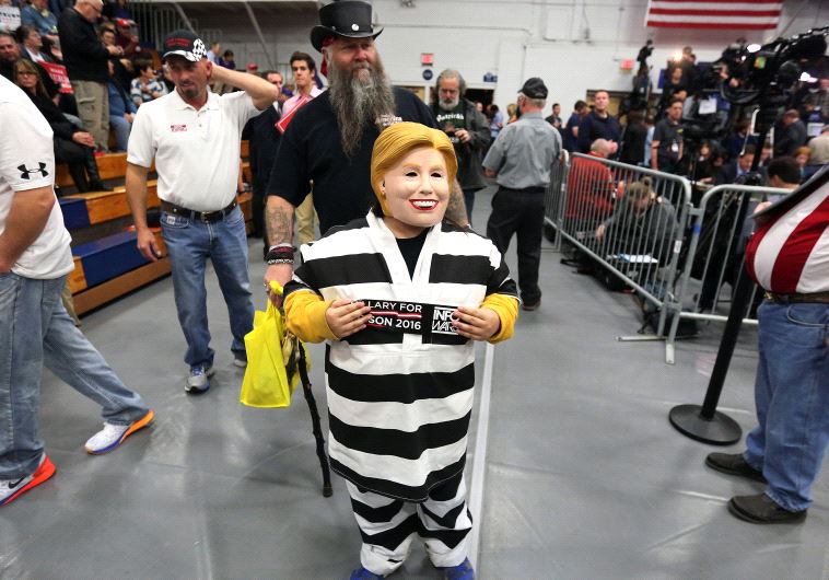 A child wears a Hillary Clinton costume before Republican presidential nominee Donald Trump holds a 