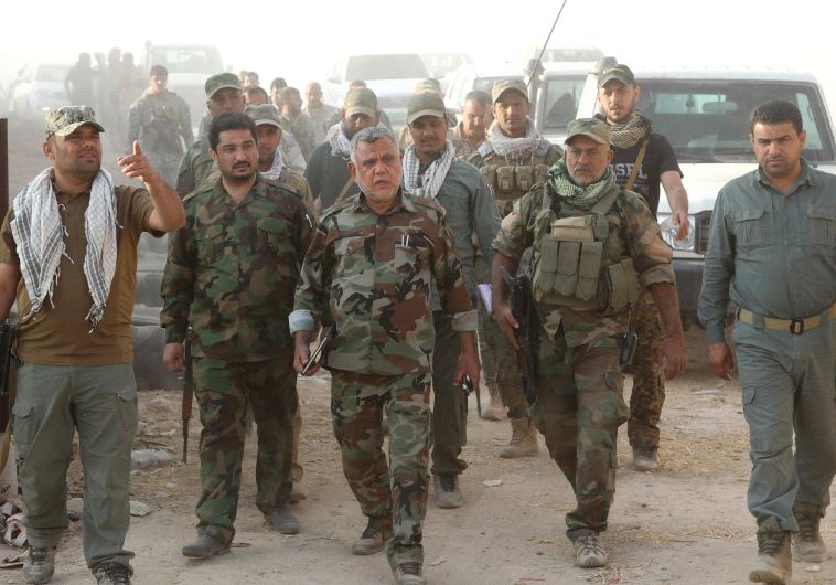 HADI AL-AMARI (center) the head of the pro-Iranian Badr Organization walks with Shi’ite fighters sou