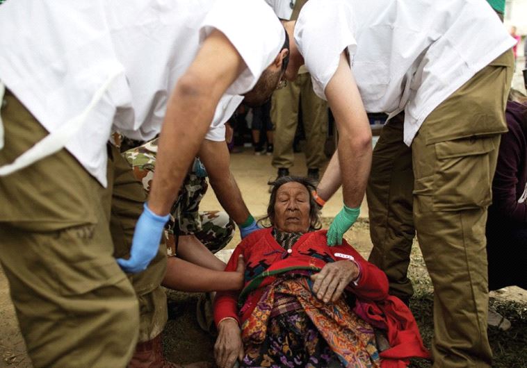 DOCTORS HELP an injured resident at the IDF field hospital in Kathmandu in 2015.