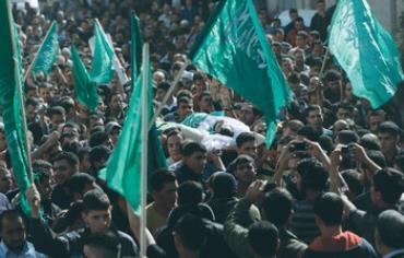 A crowd waves Hamas flags during an Islamist's funeral