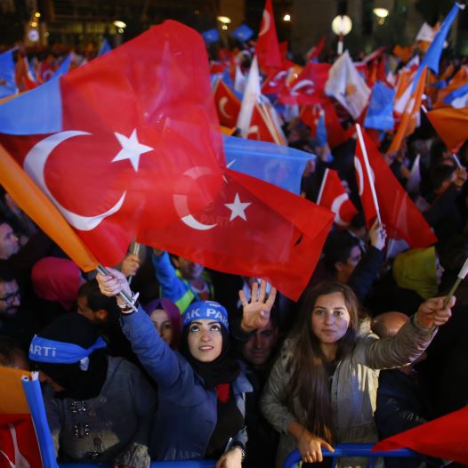Women wave flags outside the AK Party headquarters in Ankara, Turkey