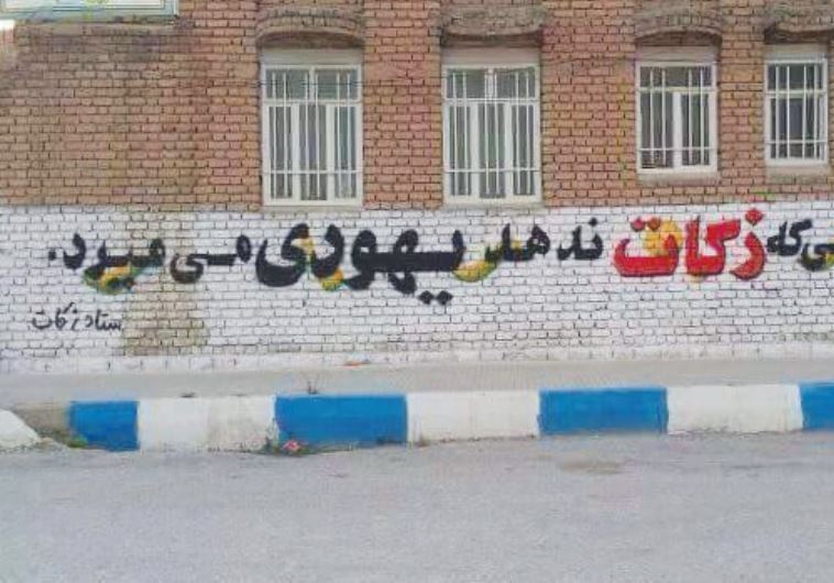 THIS GRAFFITI on a wall in Iran reads: He who does not give charity dies as a Jew.