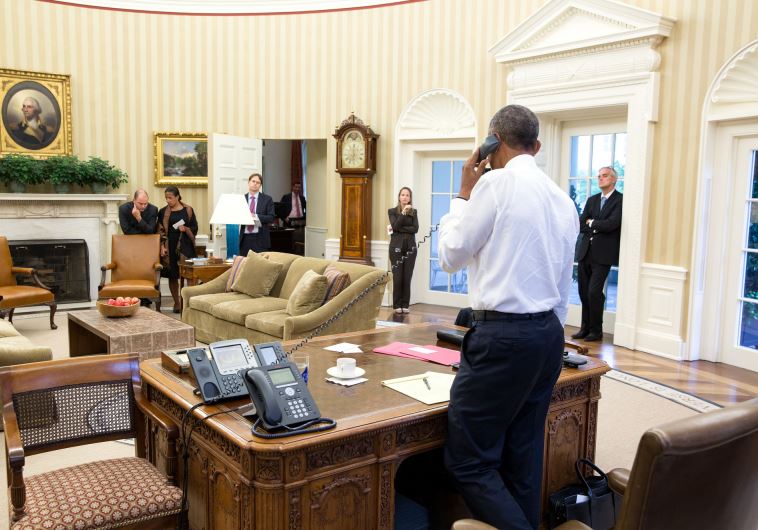 President Barack Obama talks on the phone in the Oval Office with Secretary of State John Kerry