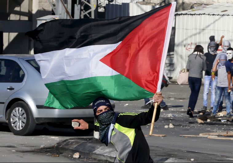 A Palestinian protester throws stones during clashes with Border Police in east Jerusalem