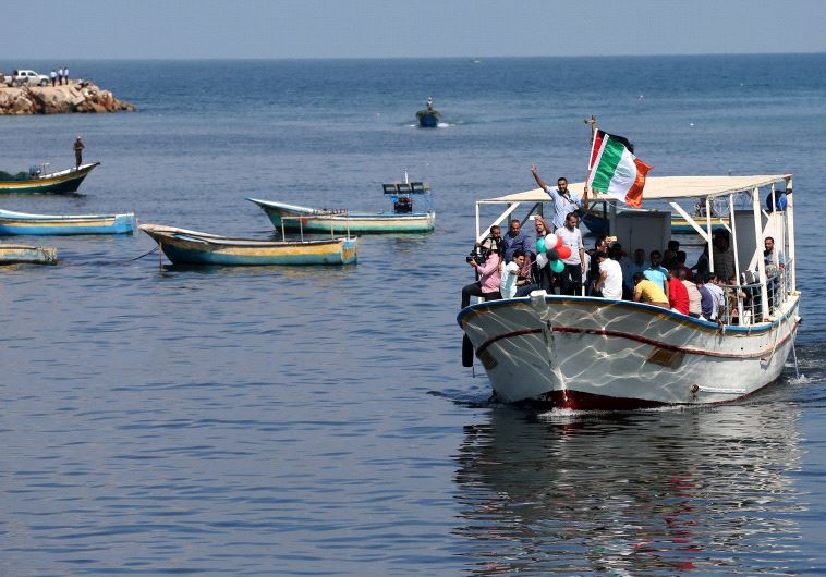 Palestinians ride a boat as they take part in a rally to show solidarity with Gaza-bound flotilla Oc