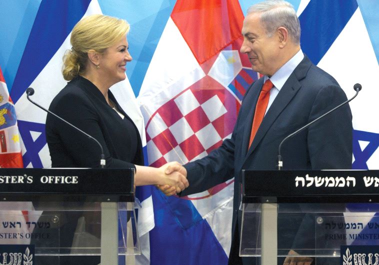 PRIME MINISTER Benjamin Netanyahu and Croatian President Kolinda Grabar-Kitarovic shake hands during