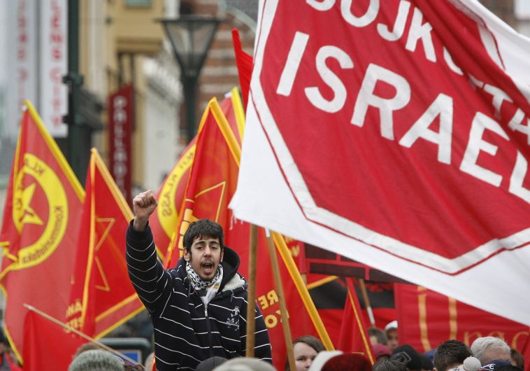 A protester chants slogans near a banner reading "Boycott Israel" during an anti-Israel march