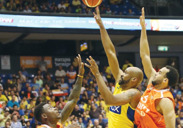 Maccabi Tel Aviv forward Devin Smith (center) attempts a shot during his team's win