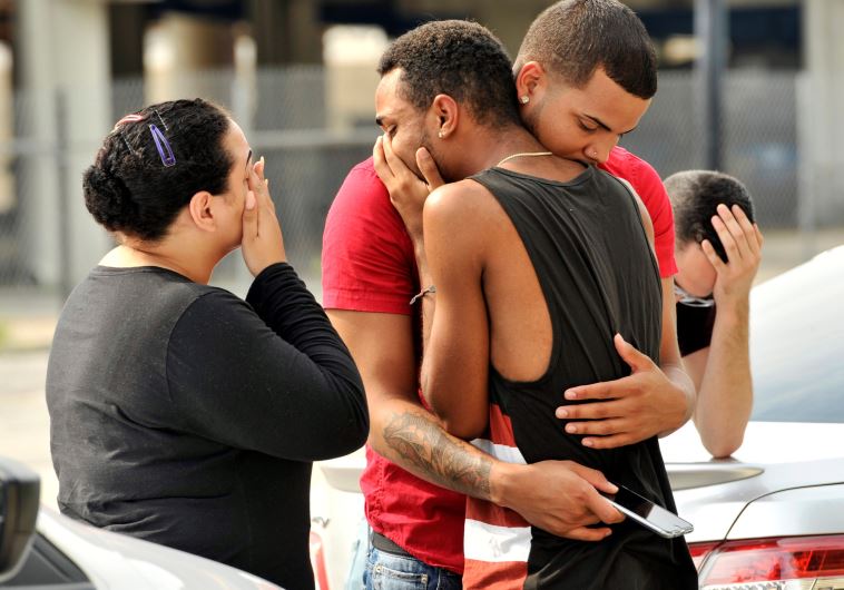 Friends and family members embrace outside the Orlando Police Headquarters during the investigation 