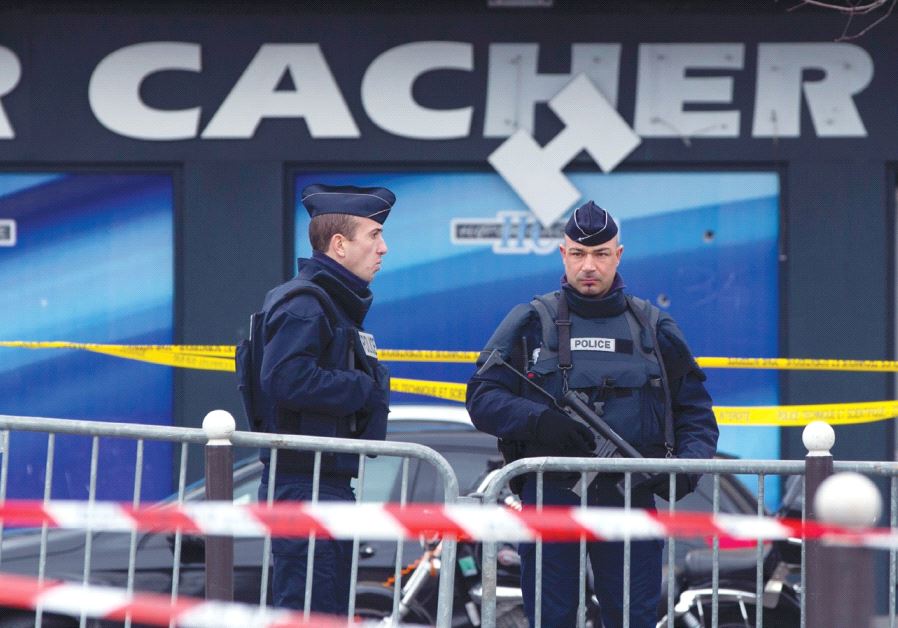 FRENCH POLICE OFFICERS stand guard outside the Hyper Cacher supermarket in Paris on January 10, 2015