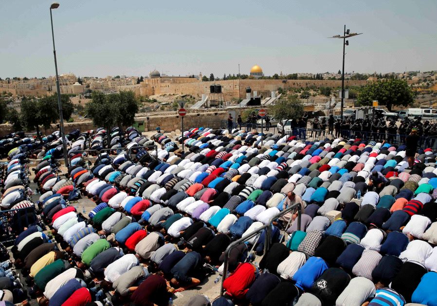 Palestinians pray on a street near a road block outside Jerusalem's Old City July 21, 2017.
